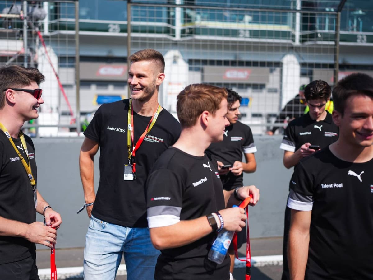 Young racing drivers on a track walk in the paddock